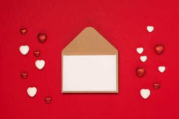 Red white hearts and empty envelope on red background. Valentines day concept. Flat lay, top view, copy space.