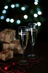two glasses of champagne on a dark background with bokeh