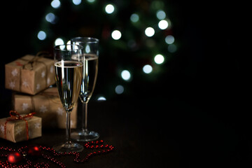 two glasses of champagne on a dark background with bokeh
