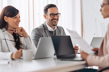 Portrait of cheerful elegant businessman smiling at the meeting