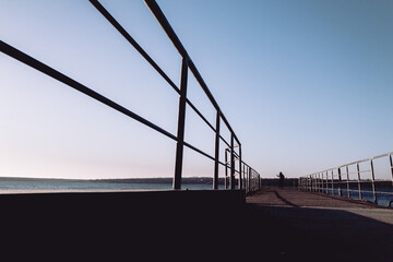 silhouette of person walking on bridge