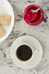 Crispbread with jam for Breakfast on a gray background. A jar of Fresh Honey with foam is next to a Cup of coffee. A minimum of calories. proper nutrition