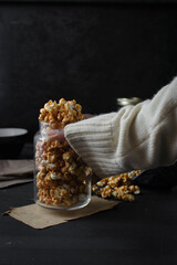 Female hand holding a glass jar of  homemade caramel popcorn