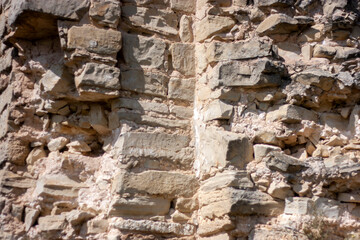 Masonry of the old building. The wall of the building collapses from time to time. The stones in the wall crumble over time.