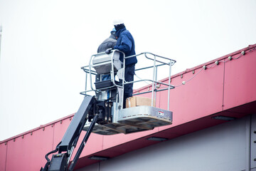 High-altitude works. Professional installation work on a construction building site. Assemblers...