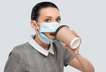 Young woman with a mask on her face drinks coffee in the office. Health care.