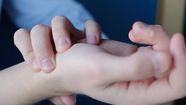 Man measuring pulse by hand with fingers at the base of the hand, close-up