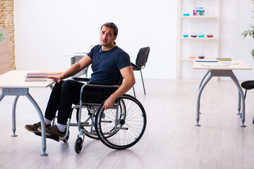 Young male student in wheel-chair preparing for exams