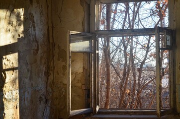 We see a window and part of a room inside an old, abandoned building