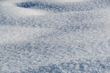 Gentle soft snowdrifts on frosty day. Winter landscape with snow covered field