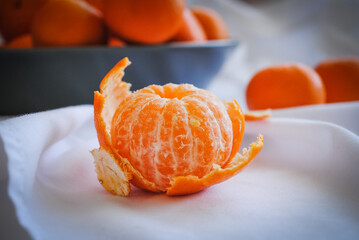 Ripe juicy tangerines in a deep ceramic plate.