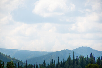Rocky ridge on horizon under blue cloudy sky. Mountain valley for travel. Adventure travel, tourism and conservation concept.