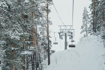 Chair lift in snowy winter landscap. Chairlift over frost forest