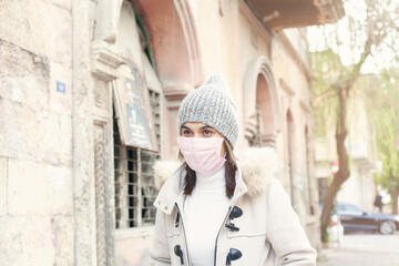 Obraz premium Young woman wearing a mask on street. 
