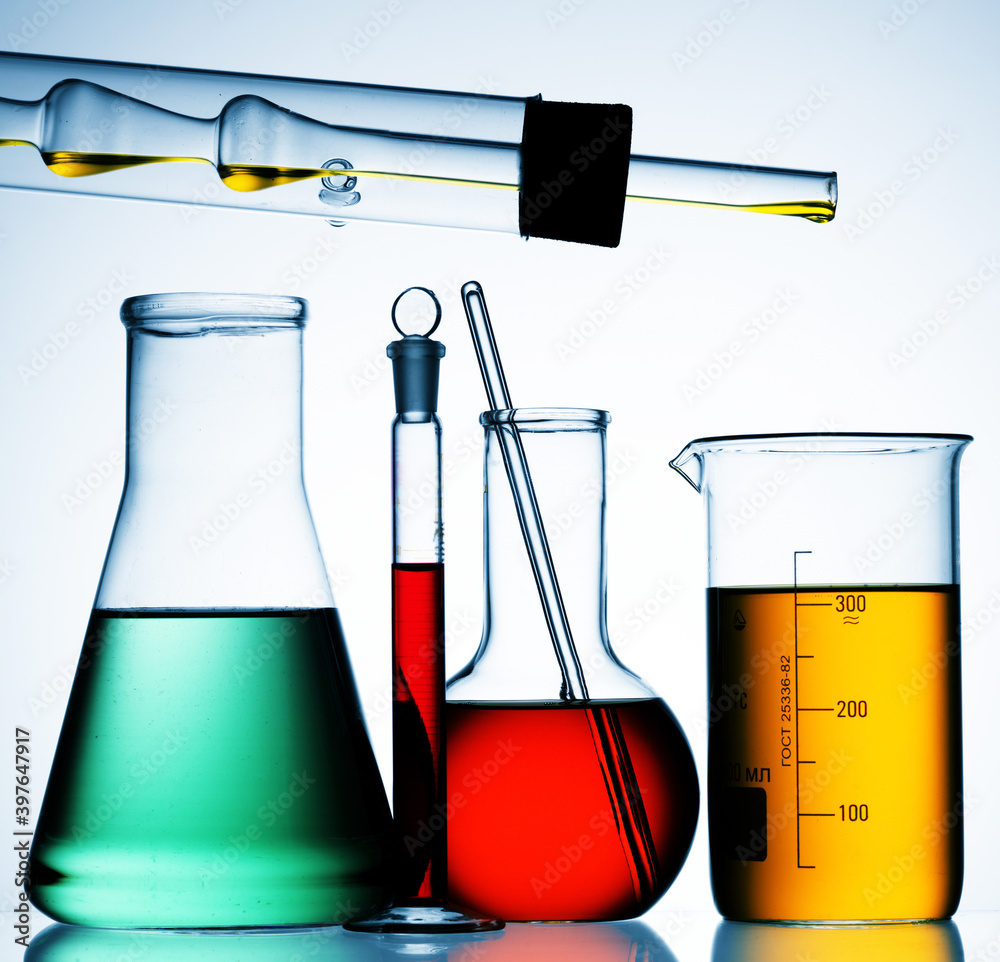 Wall mural different laboratory glassware with color liquid and with reflection