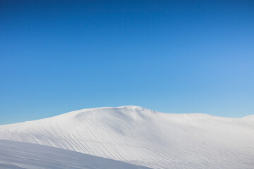 Dune de neige au sommet d'une montagne sous un beau ciel bleu