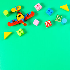 Set of colorful baby kids toys on light green background. Top view, flat lay