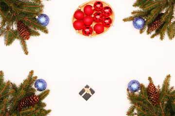  Fir branches with cones lie on a wooden background decorated with Christmas cookies and Christmas balls.