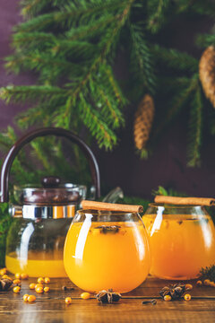  Sea buckthorn warm vitamin tea in a glass on a wooden board on a dark background, copy space for you text