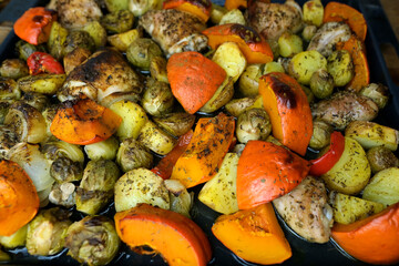 delicious vegetables baked in the oven, pumpkin, broccoli, onions, potatoes, chicken meat, delicious homemade food cooking concept