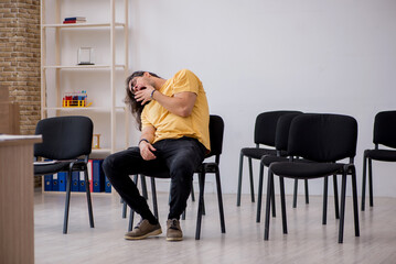 Young male student waiting for teacher in the classroom