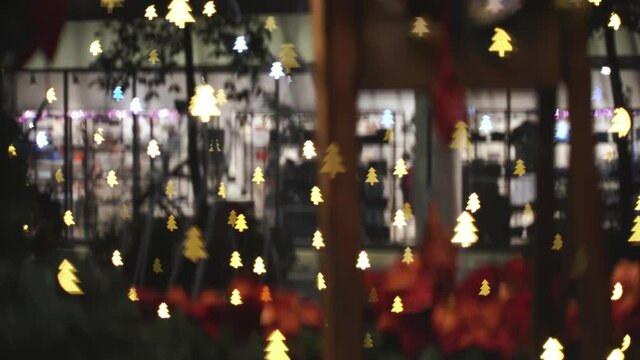 Blurry christmas tree with background fountain and shopping center. Winter holiday window shopping concept