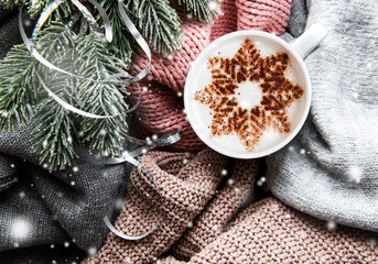 Сoffee with a snowflake pattern on a warm knitted sweaters