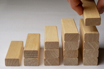 Hand arranging wood block stacking as step stair on wooden table. Business concept for growth success process. Copy space
