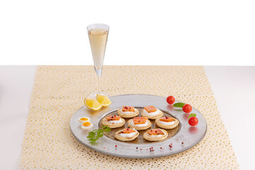 toast of smoked salmon on a dish with champagne