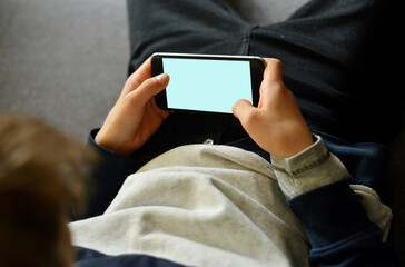 A kid holding a smartphone with in his hands digital virtual connection symbol