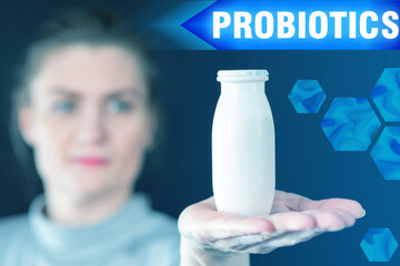 Treatment with probiotics. Girl shows a bottle with probiotics. Woman shows a biotic supplement. Treatment with live microorganisms. Beneficial bacteria treatment. Use of probiotics in healthcare.