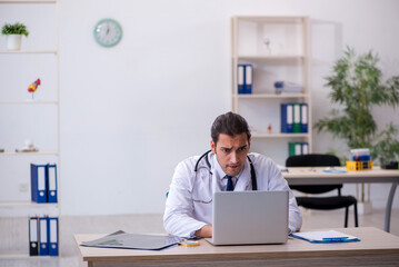 Fototapeta premium Young male doctor in telemedicine concept