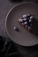 Chocolate cake with berries in a low key flatlay