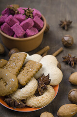Cookies and spices in an orange saucer and red sugar in a wooden bowl.