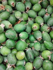 large dark green feijoa fruit on the supermarket  counter