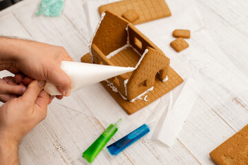 Dad and son are making a gingerbread house. Preparing for Christmas.