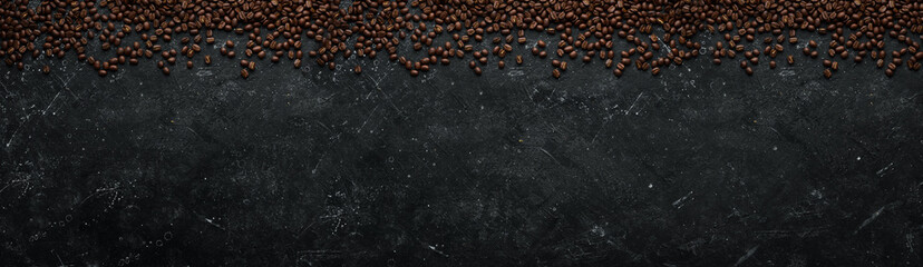 Coffee background. Coffee beans on a black stone background. Top view. Free space for your text.