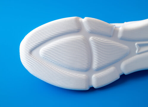 White Sheer Rubber Sole Sneaker On A Blue Background