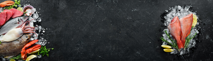 Seafood. Set of fish, crustaceans, oysters, mussels and seafood on a black stone background. Free space for your text.