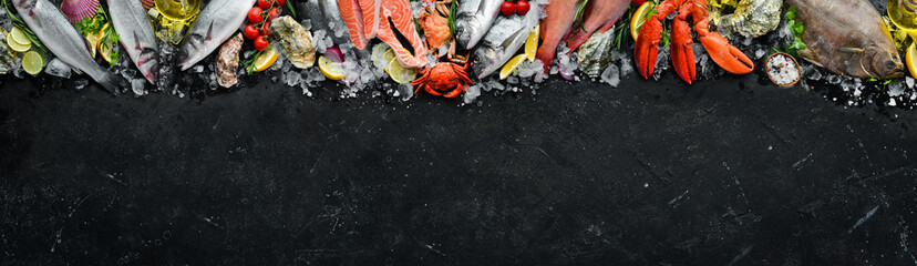 Seafood. Set of fish, crustaceans, oysters, mussels and seafood on a black stone background. Free space for your text.