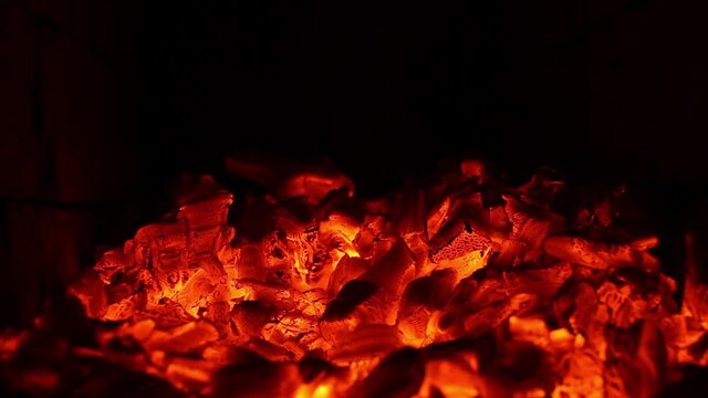 Burning coals in the fire. Red flaming coals from burning wood. Coals in the heating furnace. The fiery background.