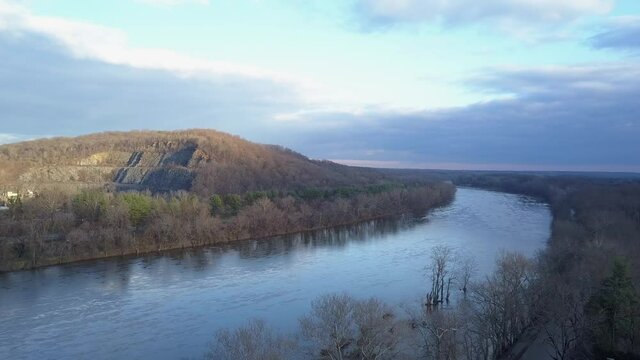 Parallax drone shot of River in winter with partly cloudy sky