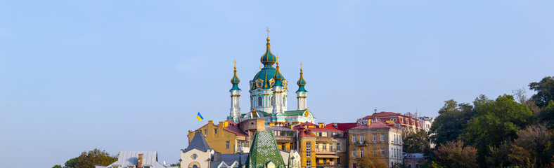 Amazing panoramic view of the slopes above the Dnieper in Kyiv, Ukraine. The ancient Baroque St. Andrew's Church rises above Andriyivskyy Uzviz and Vozdvyzhenka.