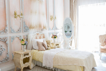 Luxurious expensive interior design of the children's room in the old Baroque style in beige colors