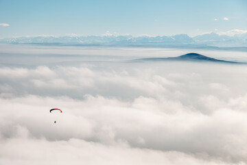 paraglider in the sky against mountains