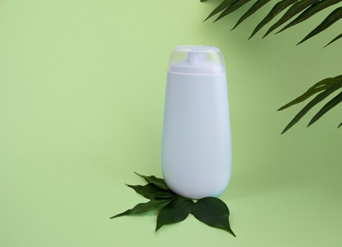 Bottle Of Cosmetics For Skin Care, Shampoo, Cream, Natural Cosmetics With Tea Tree Leaves, Tropical Leaves On A Blue Background.