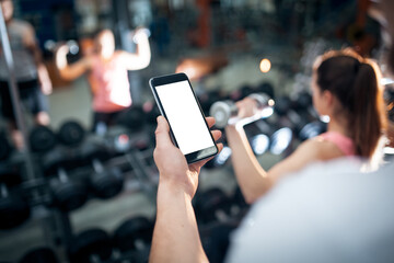 Naklejka na ściany i meble personal online workout with mobile phone or smartphone app at gym