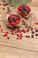 Berry muffins on metal tray. Cinnamon sticks, raisins and cranberries