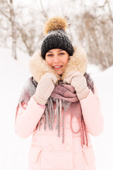 Young girl in a snowy forest in winter. Portrait of a girl in a winter park with running snow. Against the background of white snow