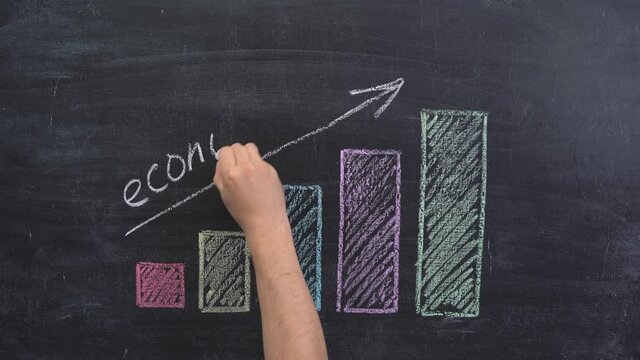 The hand draws an arrow above the growth graph on a chalkboard